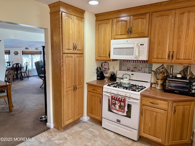 kitchen featuring light colored carpet and white appliances