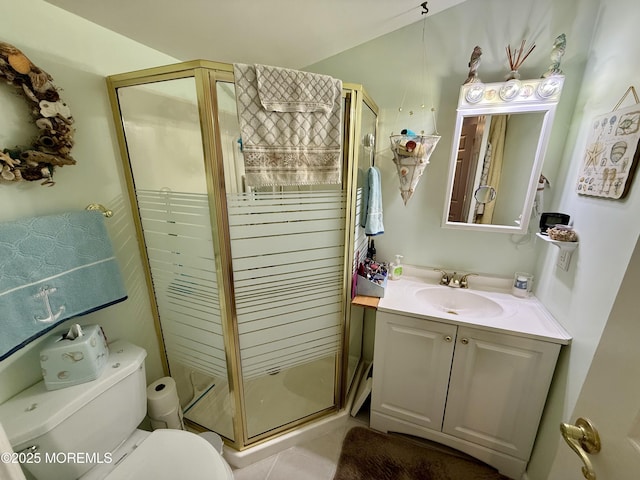 bathroom featuring toilet, tile patterned floors, vanity, and a shower with shower door