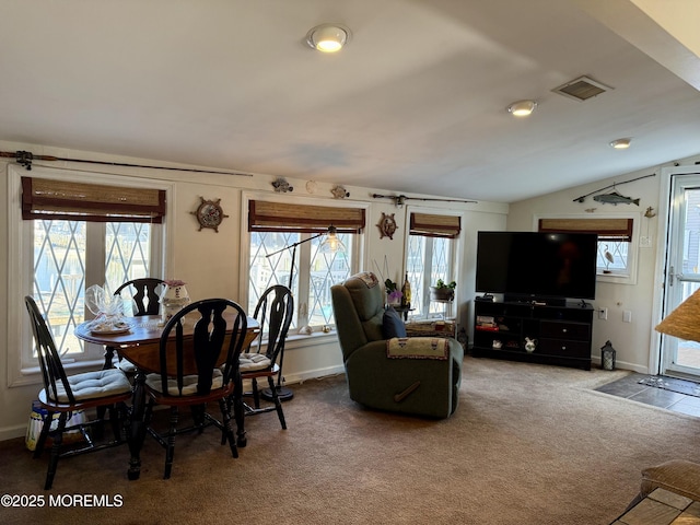 carpeted dining room with a wealth of natural light and lofted ceiling