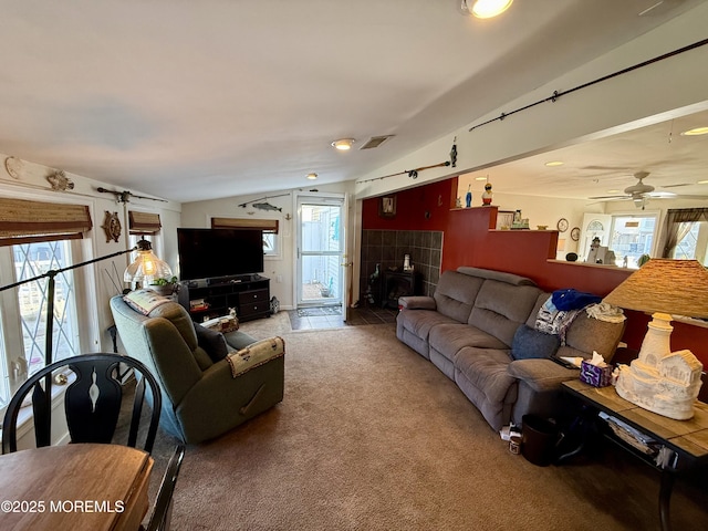 living room with ceiling fan, vaulted ceiling, and carpet flooring