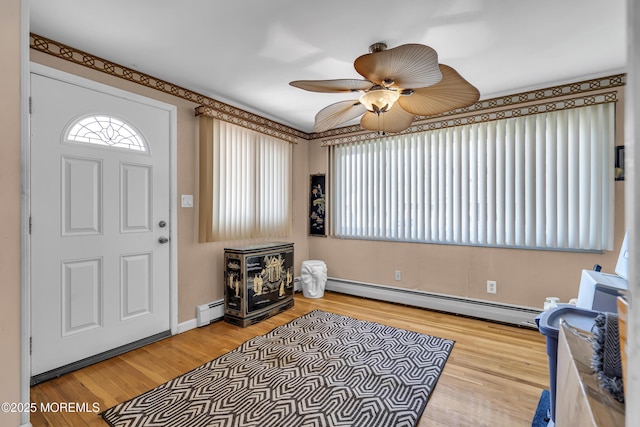 entrance foyer with wood-type flooring, a baseboard heating unit, and ceiling fan