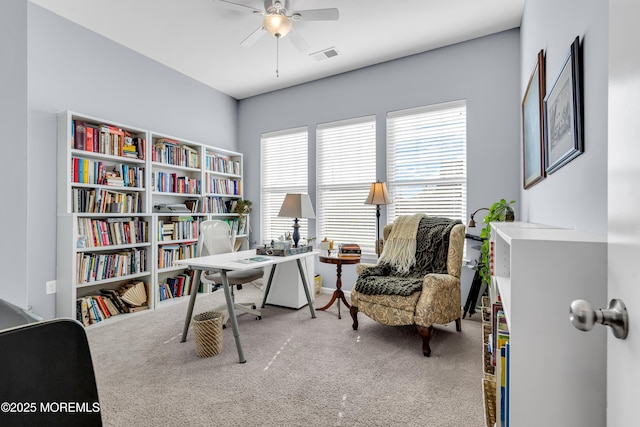 carpeted office space with ceiling fan