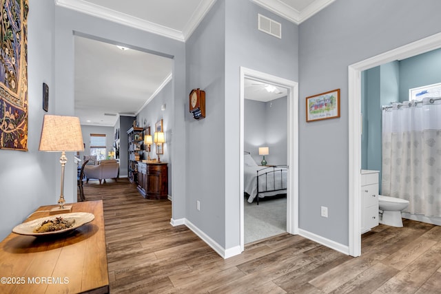 corridor with hardwood / wood-style flooring and crown molding