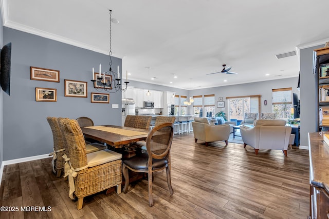 dining space featuring ceiling fan with notable chandelier, crown molding, and hardwood / wood-style floors