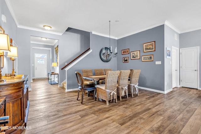 dining space featuring an inviting chandelier, hardwood / wood-style floors, and crown molding