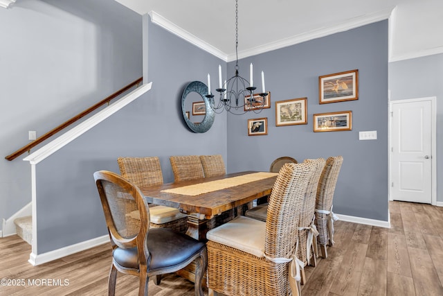 dining room with a chandelier, light hardwood / wood-style floors, and crown molding