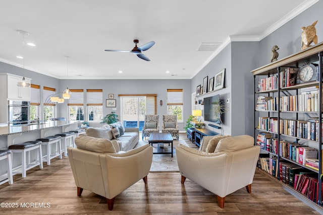 living room with ceiling fan, ornamental molding, and dark hardwood / wood-style floors