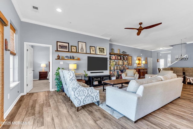 living room featuring ceiling fan with notable chandelier, ornamental molding, and light hardwood / wood-style flooring