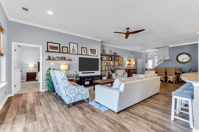 living room with light wood-type flooring, ceiling fan, and ornamental molding