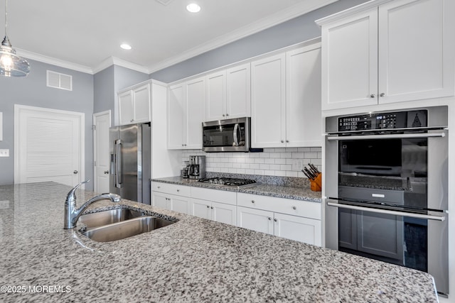 kitchen featuring light stone counters, appliances with stainless steel finishes, white cabinetry, and sink