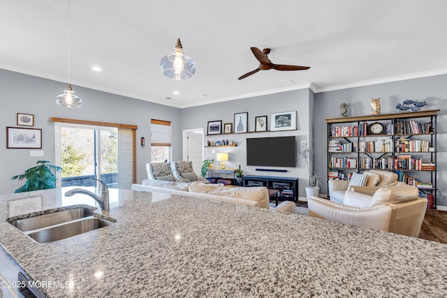 kitchen featuring sink, ceiling fan, decorative light fixtures, and light stone countertops