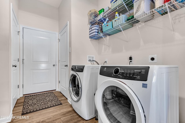 clothes washing area featuring separate washer and dryer and wood-type flooring