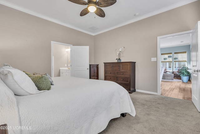 carpeted bedroom featuring ensuite bath, ceiling fan, and ornamental molding