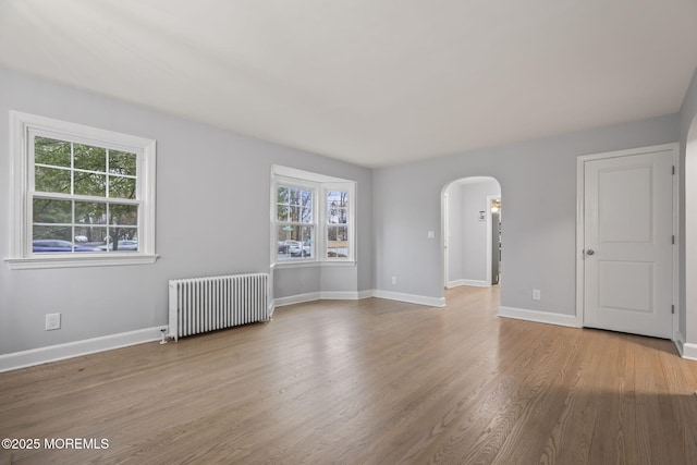 empty room featuring light hardwood / wood-style floors and radiator heating unit