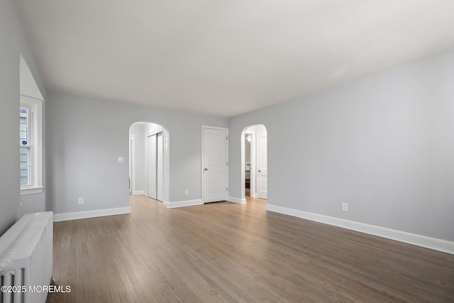 spare room with radiator and hardwood / wood-style floors