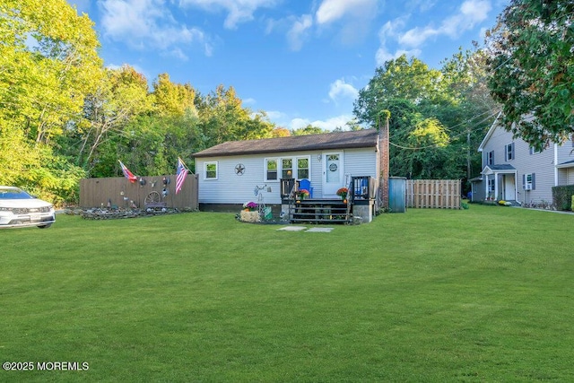 rear view of house featuring a yard and a wooden deck