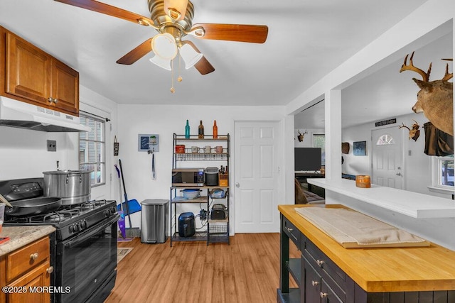 kitchen featuring ceiling fan, black range with gas cooktop, light hardwood / wood-style floors, and wood counters