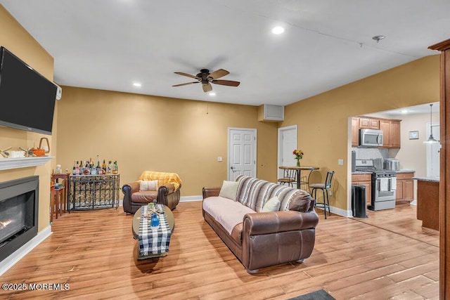 living room with ceiling fan and light wood-type flooring