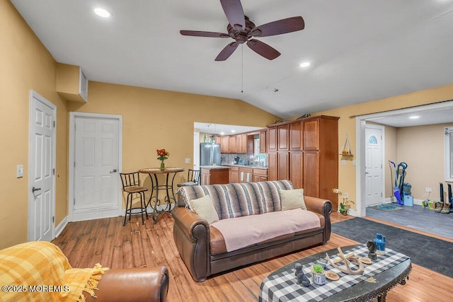 living room featuring lofted ceiling, ceiling fan, and light hardwood / wood-style floors