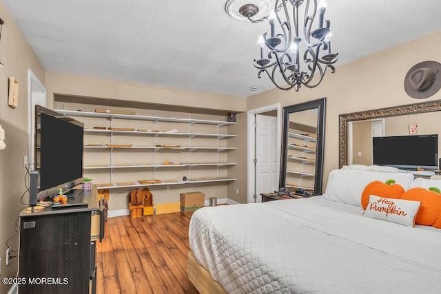 bedroom featuring wood-type flooring and a chandelier