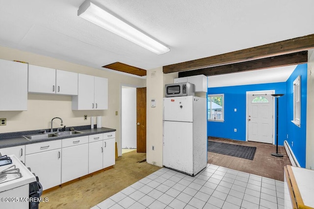 kitchen featuring sink, white appliances, and white cabinetry