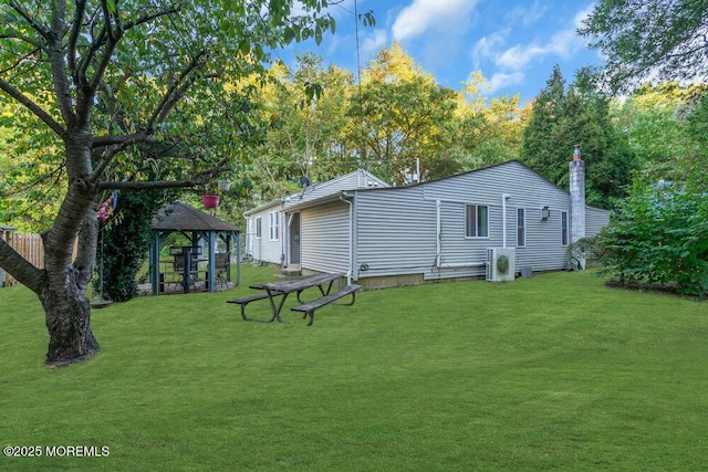 back of house with a gazebo, ac unit, and a lawn