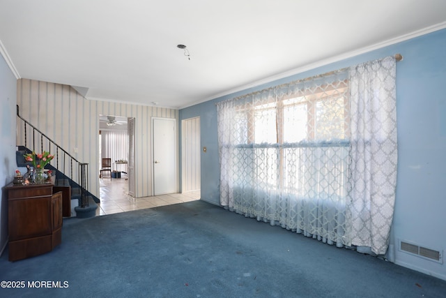 carpeted spare room with ceiling fan and ornamental molding