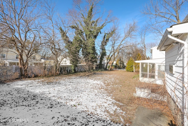 snowy yard featuring a sunroom