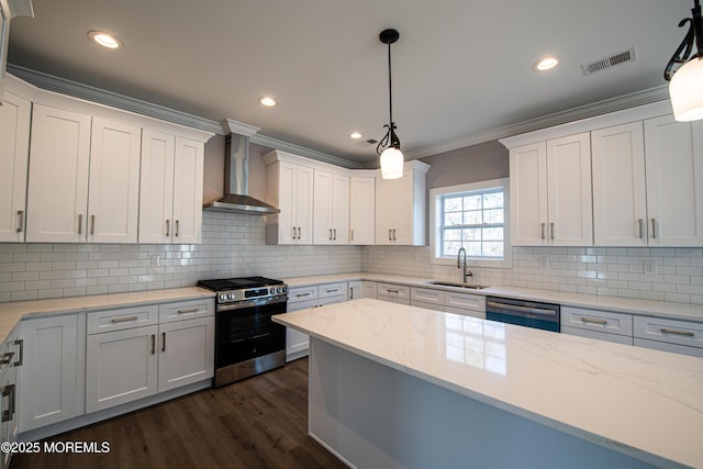 kitchen featuring white cabinets, appliances with stainless steel finishes, and wall chimney range hood