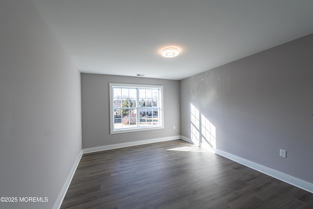 empty room with dark hardwood / wood-style flooring