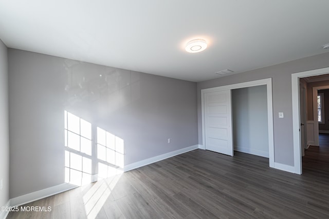 unfurnished bedroom with dark hardwood / wood-style floors and a closet