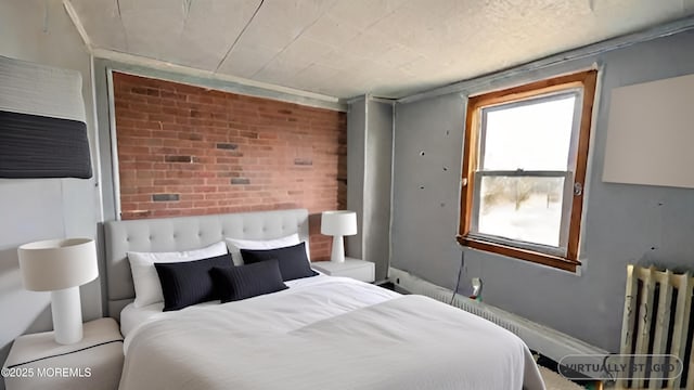 bedroom with radiator and brick wall