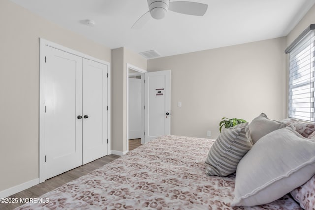 bedroom with ceiling fan, wood-type flooring, and a closet