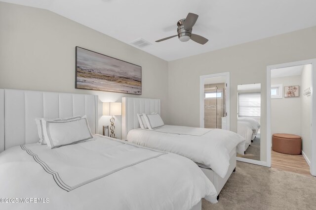 bedroom with ensuite bathroom, vaulted ceiling, and ceiling fan