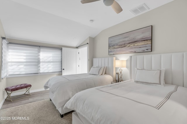 bedroom with ceiling fan, lofted ceiling, and light hardwood / wood-style floors