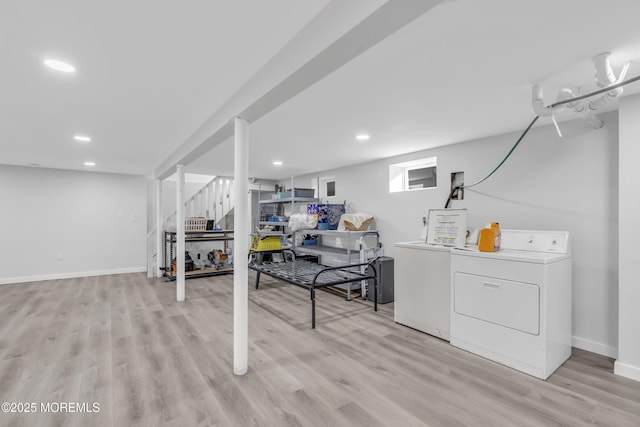 basement with washing machine and clothes dryer and light hardwood / wood-style flooring