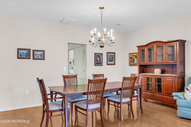 dining area featuring an inviting chandelier and light hardwood / wood-style floors