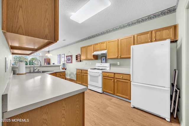 kitchen featuring white appliances, light hardwood / wood-style floors, kitchen peninsula, a textured ceiling, and sink