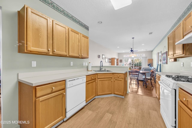 kitchen with white appliances, kitchen peninsula, ceiling fan, sink, and decorative light fixtures