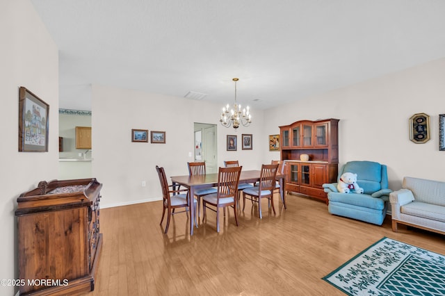 dining room featuring an inviting chandelier and light hardwood / wood-style flooring