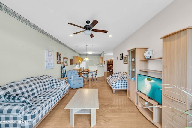 living room featuring ceiling fan and light hardwood / wood-style flooring