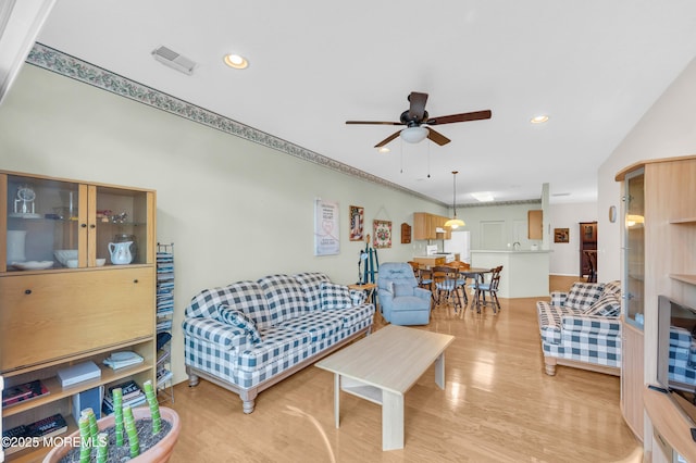 living room featuring ceiling fan and light hardwood / wood-style floors