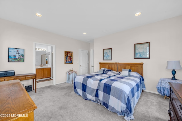 carpeted bedroom with sink and ensuite bath