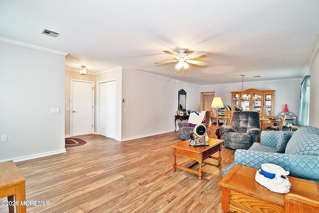 living room with ornamental molding, ceiling fan, and light hardwood / wood-style flooring