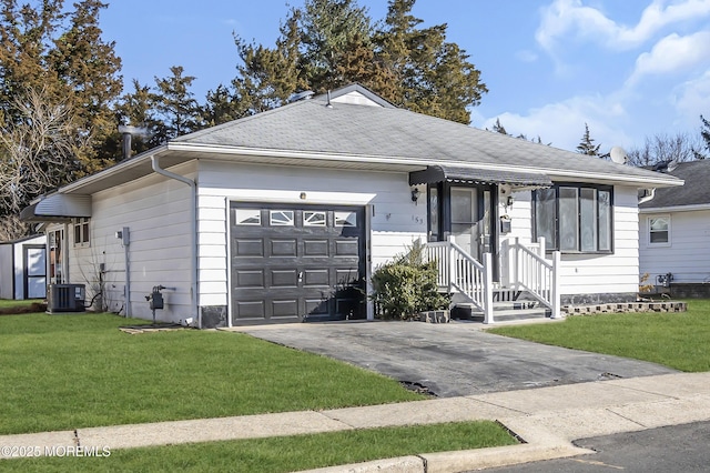 single story home featuring a garage, cooling unit, and a front lawn