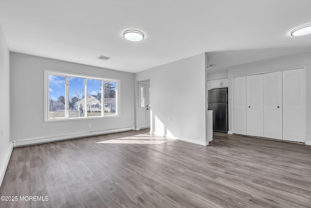 unfurnished living room with light wood-type flooring and a baseboard heating unit