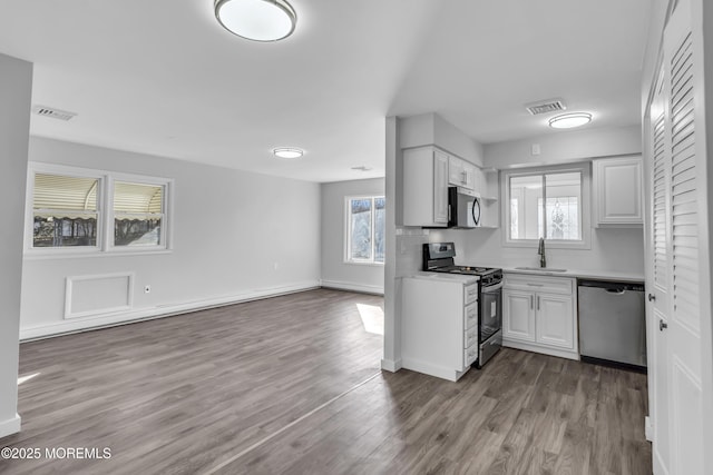 kitchen with sink, white cabinetry, stainless steel appliances, and a wealth of natural light