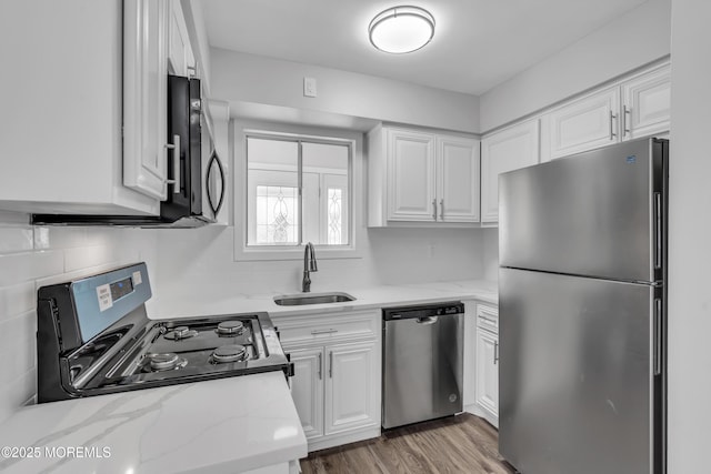 kitchen featuring white cabinets, light stone counters, and stainless steel appliances