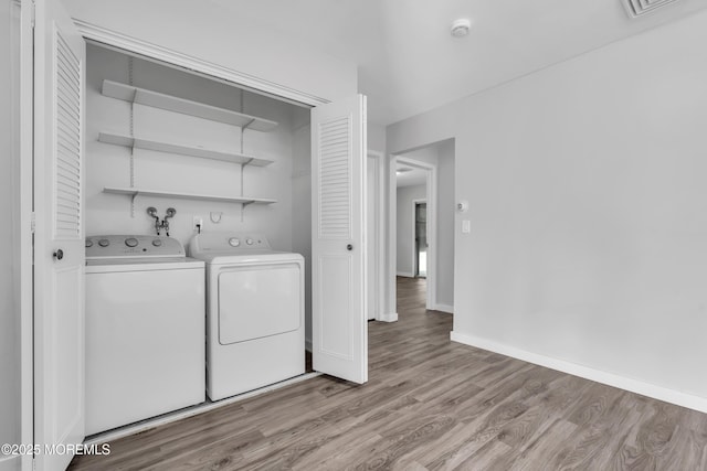 washroom featuring light hardwood / wood-style flooring and washing machine and dryer