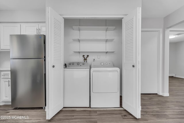 laundry room featuring light hardwood / wood-style flooring and washing machine and dryer